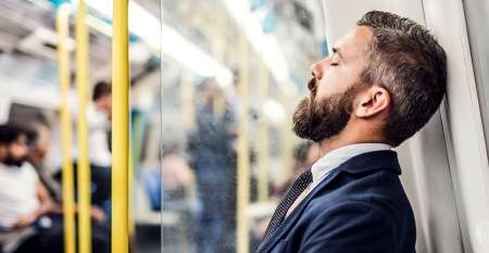 Tired businessman seated on tube train