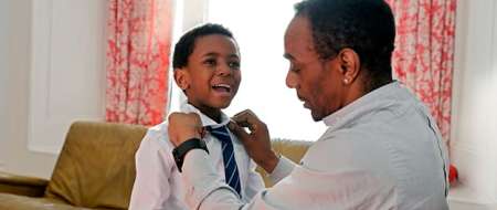 Man tying young boys tie